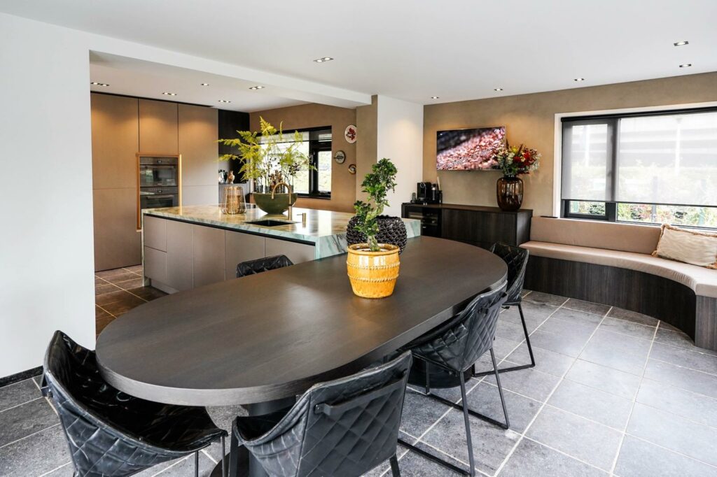 Moderne keuken van TK Studio met Mereno Milano Monza front in metallic kleur, groot eiland met aansluitende eettafel en ronde zithoek