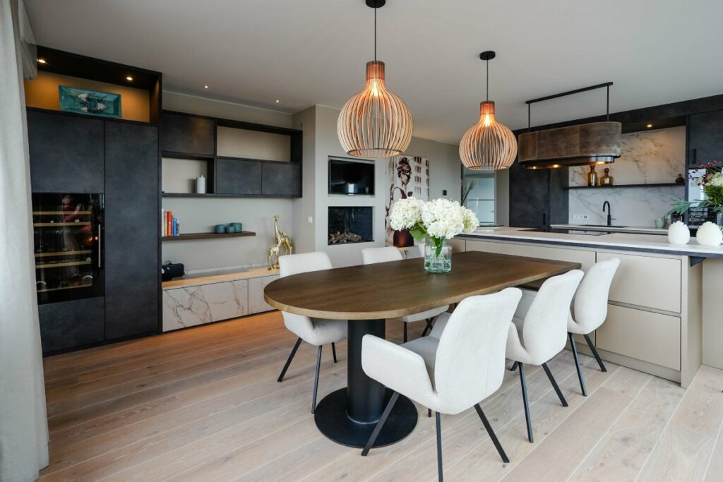 Moderne keuken van TK Studio met eettafel aan eiland en hoge kastenwand met klimaatkast, Mereno Monza Milano front in metallic kleur