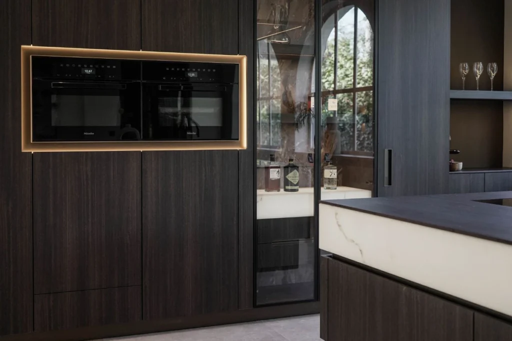 Moderne keuken van TK Studio met Mereno Monza front hoge kastenwand met apparatuur en glaskasten