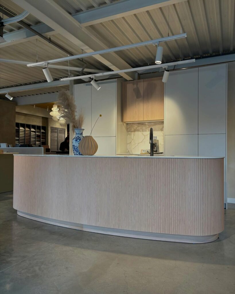 Japandi showroomkeuken van Puur keukens met organisch eiland, Mereno Milano front in wit en eiken