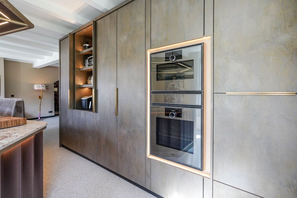 Hoge kastenwand met Decolegno materiaal en apparatenombouw